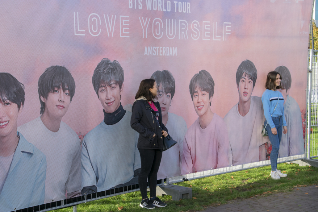 Plakatwand mit BTS und Fans 